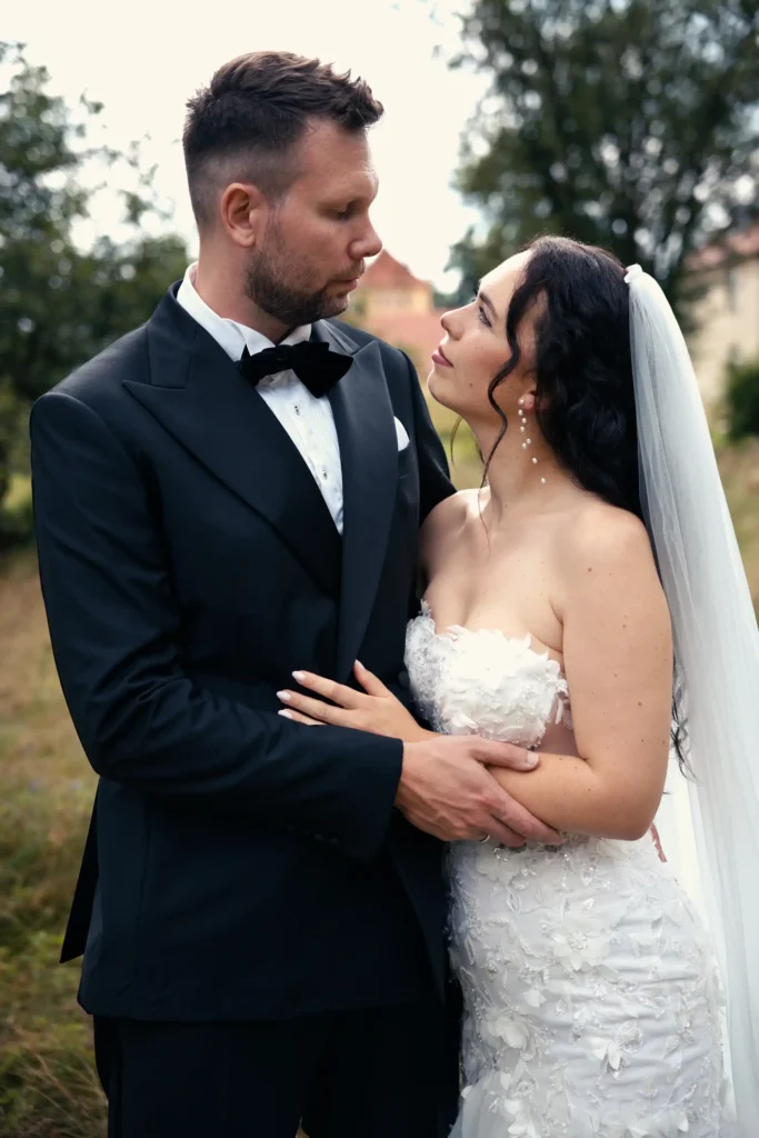 Braut mit langem Schleier und Bräutigam im dunklen Anzug blicken einander an – Paarporträt zur Hochzeit in Görlitz.