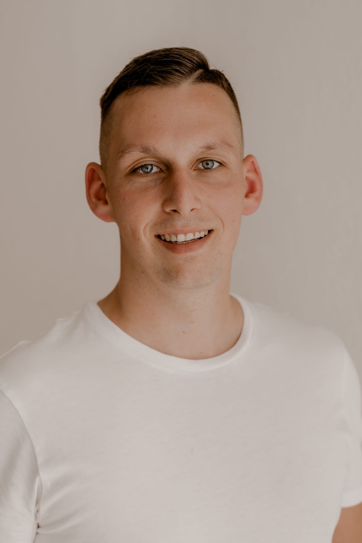 Stefan Bergner lächelt im weißen T-Shirt in die Kamera – euer Hochzeitsvideograf für einen Hochzeitsfilm für Dresden.